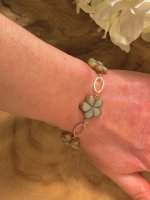 Armband goudkleurig met bloem steentjes grijs-wit